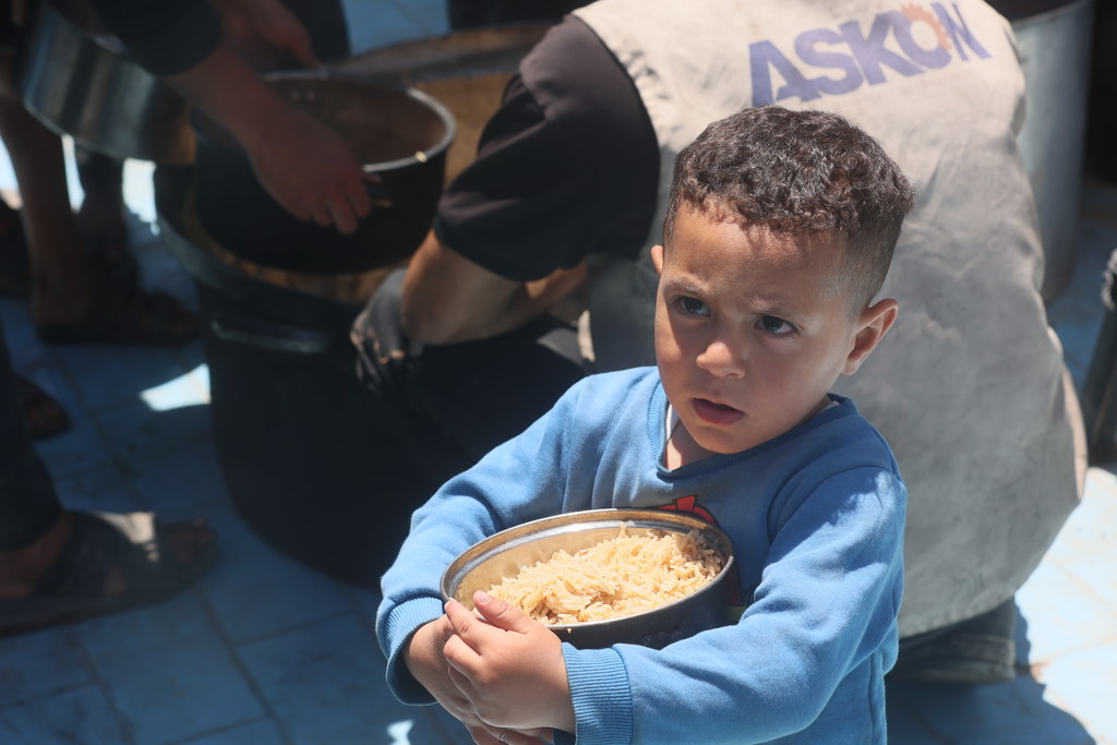 طفل يحمل إناء مليئا بالأرز.